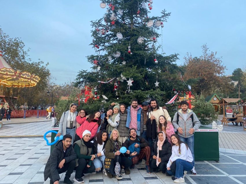 Alicia with a group beside a decorated tree